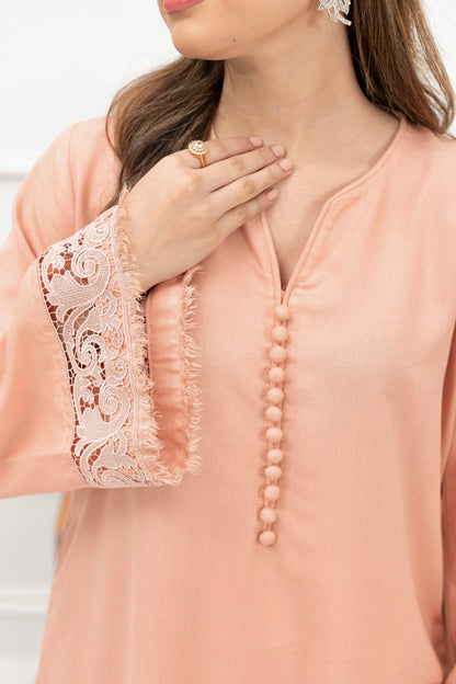 Close-up of embroidered sleeve detail on powder pink karandi kurta with delicate stitching.