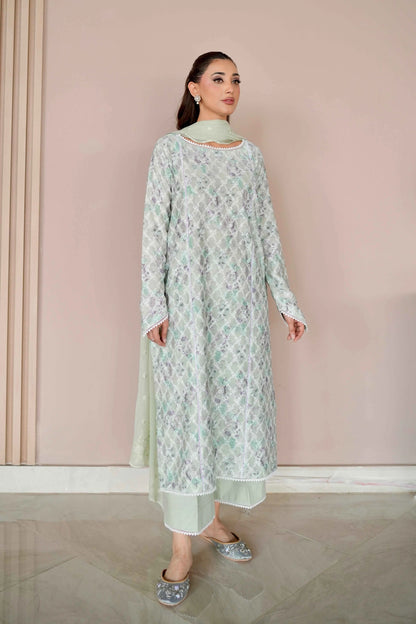 Woman wearing a light green floral dress against a pink wall - Meryl Wear