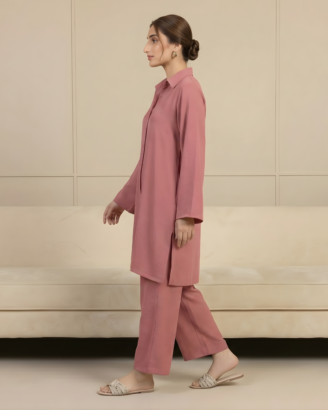 Woman wearing a pink outfit standing against a beige wall dress by Meryl Wear