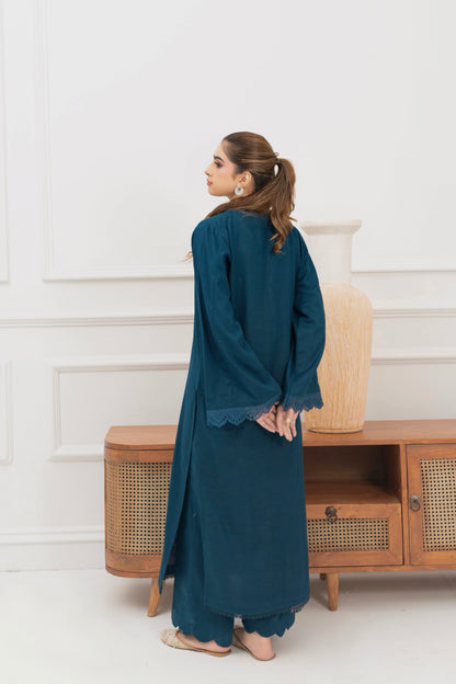Angled look at deep teal khaddar ready-to-wear outfit styled against a white background.