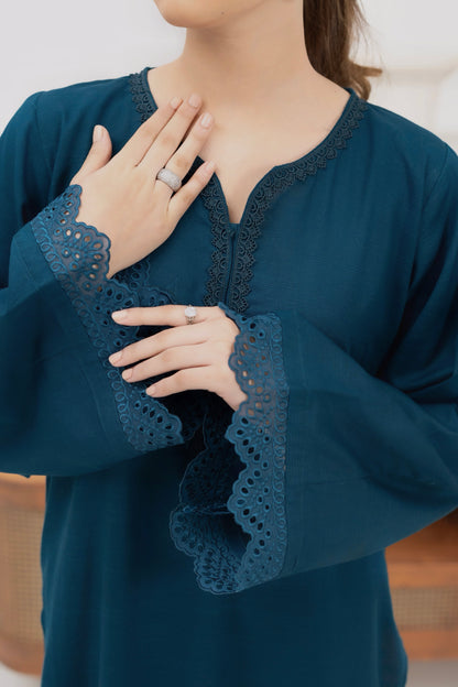 Close-up of embroidered sleeve detail on deep teal khaddar kurta with intricate stitching.